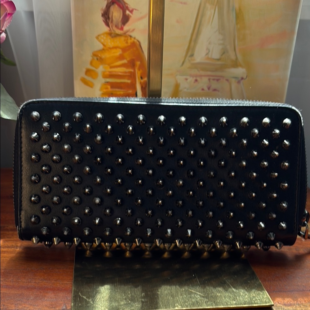 Pre-loved Christian Louboutin black zipper wallet red leather interior.